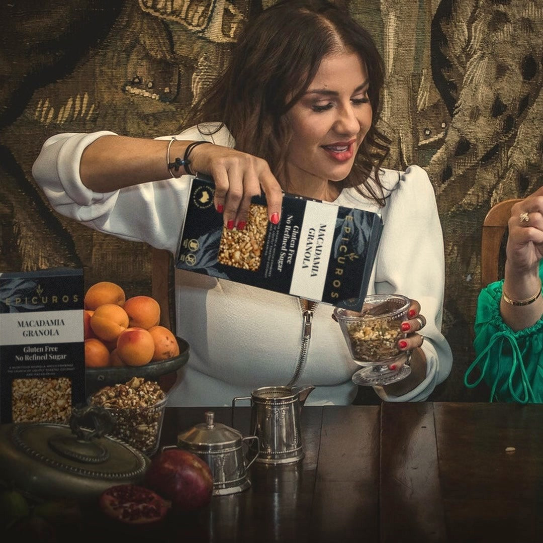 Sofia pouring Macadamia Granola from the navy box at the breakfast table